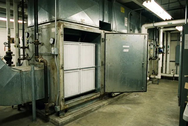 Service AHU air handling unit di ruang mesin gedung komersial