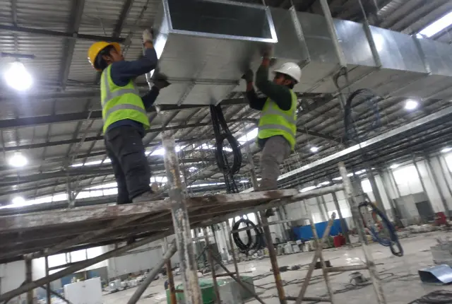 Pekerja memasang ducting BJLS di plafon pabrik di kawasan industri Cikarang